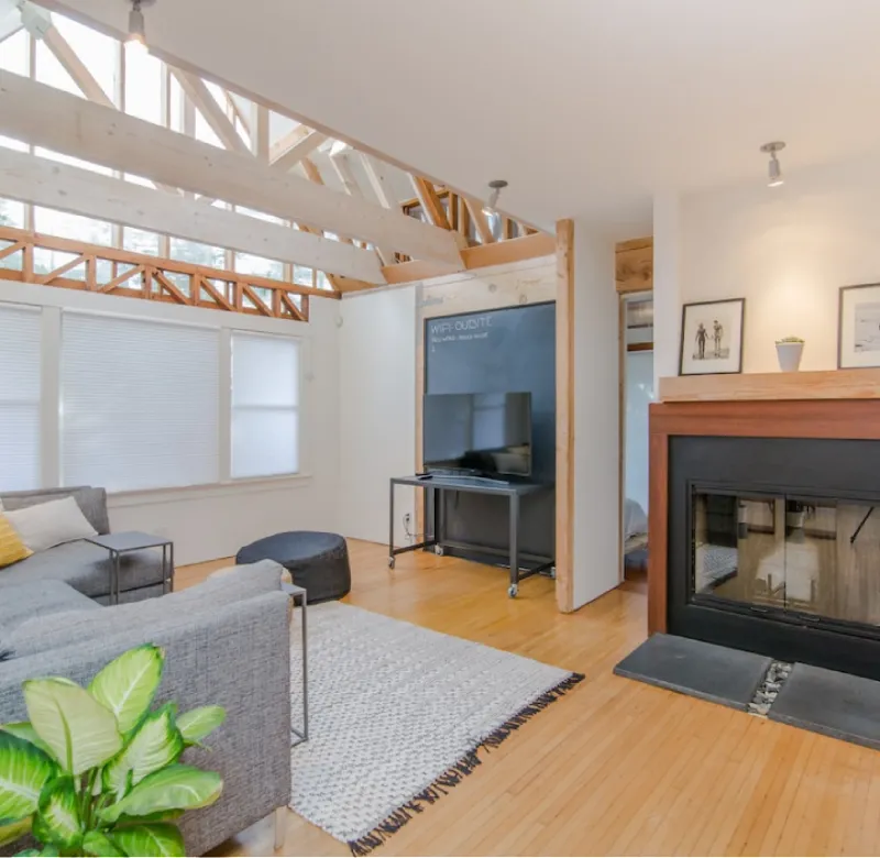 Modern living room with fireplace and exposed beams.