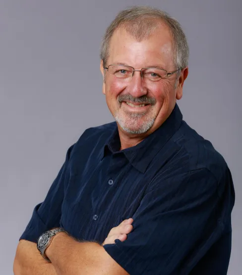 Smiling man with glasses and navy shirt.