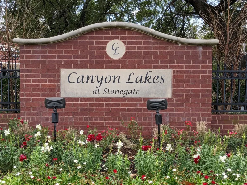 Canyon Lakes at Stonegate sign with flowers.